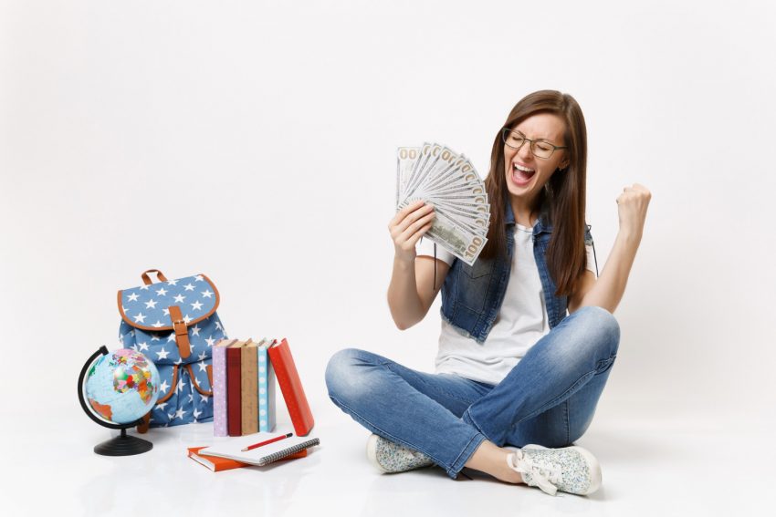 Happy student woman holds a lot of cash dollars